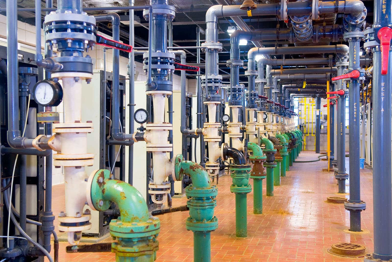 Interior of a drinking-water treatment plant with process piping, valves, and gauges